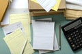 Top view of working process in the accountant office.Pile of bills, documents, notebook, calculator on the blue desk