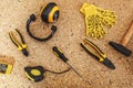 Top view of working tool: noise insulated headphones, tape measure, yellow gloves, wrench, screwdrivers, hammer, pliers Royalty Free Stock Photo