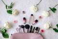 Top view, workspace, bag for cosmetic brushes, makeup and flowers Royalty Free Stock Photo