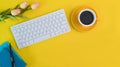 Top view workspace keyboard, coffee, diary with flower, Flat layout yellow office desk.