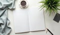 Top view of workspace with open notebook coffee cup plant pen and dark notepad. Flat lay of desk with blank pages for text or Royalty Free Stock Photo