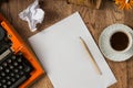 Top view of workspace of vintage orange typewriter paper and cup of coffee Royalty Free Stock Photo