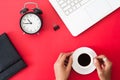 Top view of workspace, woman hand holding cup of coffee, alarm c Royalty Free Stock Photo