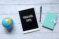 Top view of world globe,notebook,pen and tablet pc written with TRAVEL TIPS on wooden background Royalty Free Stock Photo