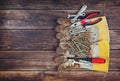 Top view of worn work gloves and assorted work tools over wooden background