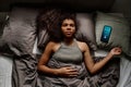 Top view of worried African American female teenager keeping head on pillow