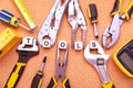 Top view of wrenches, screwdrivers and pliers near cubes with TOOLS sign on cork table