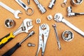 Top view of wrenches, screwdrivers and pliers near cubes with TOOLS sign on cork table