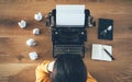 Top view of writer above typewriter and crumpled papers around