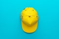 Top view of yellow baseball cap on turquoise blue background with copy space Royalty Free Stock Photo