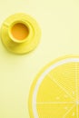 Top view of a yellow cup of tea and a lemon placemat in a yellow background Royalty Free Stock Photo