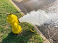 Top view yellow fire hydrant gushing water across a residential street near Dallas, Texas, USA Royalty Free Stock Photo