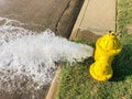 Top view yellow fire hydrant gushing water across a residential street near Dallas, Texas, USA Royalty Free Stock Photo