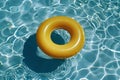 Top view of yellow floating tire in water in swimming pool