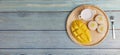 Top view Yellow half mango with small fork. Mango fruit cubes on the Blue wooden table. Tropical fruit asia. Fresh yellow mango