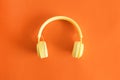 Top view of yellow headphones on a pastel orange background, ntertainment concept
