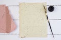 Top view of yellow paper, quill pen and ink on white deck table Royalty Free Stock Photo