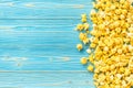 Top view yellow popcorn on blue wooden plank background Royalty Free Stock Photo