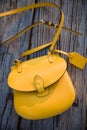 Top view on yellow purse on the old wooden table background. Nice woman`s bag Royalty Free Stock Photo