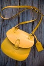 Top view on yellow purse on the old wooden table background. Nice woman`s bag Royalty Free Stock Photo