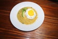 Top view yellow rice plate with egg omelette, plums, mint leaf,lemon slice on white plate on wood table Royalty Free Stock Photo