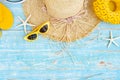 Top view of yellow slippers summer hat and sunglasses on blue wooden background,Flat lay of summer and travel equipment with copy