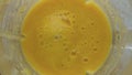 Top view yellow smoothie splashing in blender super slow motion closeup.