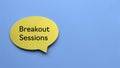 Top view of yellow speech bubble written with Breakout Sessions on blue background with copy space