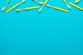 Top view of yellow toothbrushes over turquoise blue background with copy space