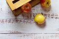 Top view of yellowish-red apples inside a wooden crate and spread out on rustic table Royalty Free Stock Photo