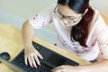 Top view of young Asian female with glasses writer keyboarding on laptop while working for online writing work Royalty Free Stock Photo