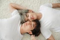 Top view of young Asian gay couple closed their eyes and lying on floor with white fluffy carpet. Their men face are very close to Royalty Free Stock Photo