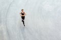 Top view of young attractive athletic woman speed running on city asphalt and workout in the morning time on a sunny summer day. Royalty Free Stock Photo