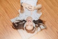 Top view of young beautiful asian woman with headphone and listening music from smartphone while lying on the floor at home Royalty Free Stock Photo