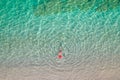 Top view. Young beautiful woman in a red hat and bikini lying and sunbathe in sea water on the sand beach. Drone, copter photo. Royalty Free Stock Photo