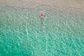 Top view. Young beautiful woman in a red hat and bikini lying and sunbathe in sea water on the sand beach. Drone, copter photo. Royalty Free Stock Photo