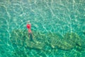 Top view. Young beautiful woman in a red hat and bikini swimming in sea water on the sand beach. Drone, copter photo. Summer Royalty Free Stock Photo