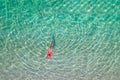 Top view. Young beautiful woman in a red hat and bikini swimming in sea water on the sand beach. Drone, copter photo. Summer Royalty Free Stock Photo