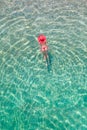 Top view. Young beautiful woman in a red hat and bikini swimming in sea water on the sand beach. Drone, copter photo. Summer Royalty Free Stock Photo