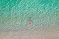 Top view. Young beautiful woman in a red hat and bikini swimming in sea water on the sand beach. Drone, copter photo. Summer Royalty Free Stock Photo