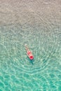 Top view. Young beautiful woman in a red hat and bikini swimming in sea water on the sand beach. Drone, copter photo. Summer Royalty Free Stock Photo