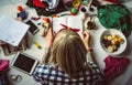 Top view of young blonde woman in a bandana read a book lying on the floor. The mess in the room. Modern student