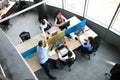 Top view of young business partners shaking hands over deal at office. Focus on hand shake. Royalty Free Stock Photo