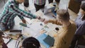 Top view of young business team working together near the table, brainstorming. Two mans fist greeting each other. Royalty Free Stock Photo