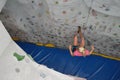 Top view of a young caucasian blonde woman rappelling at indoor artificial rock climbing wall Royalty Free Stock Photo