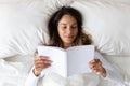 Young woman rest in cozy bed reading book at home Royalty Free Stock Photo