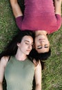 Top view of young couple with closed eyes laying on the grass on public park Royalty Free Stock Photo