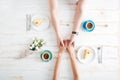 Top view of young couple holding hands and having breakfast Royalty Free Stock Photo