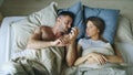 Top view of young couple lying in bed upset and argue each other Royalty Free Stock Photo