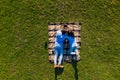 Top view of young couple lying on the blanket on green grass holding photo camera and watching photos. View from above Royalty Free Stock Photo